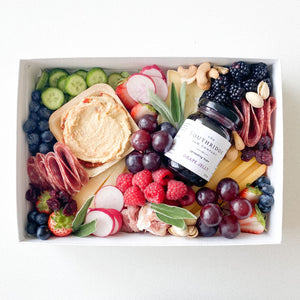 small grazing box with cheese, charcuteries, fruits, vegetables, hummus and jam